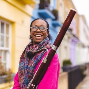 Daria Phillips in bright colours, standing with bassoon