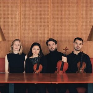 NOVO Quartet seated at table with instruments