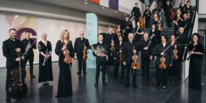 Royal Northern Sinfonia standing with instruments